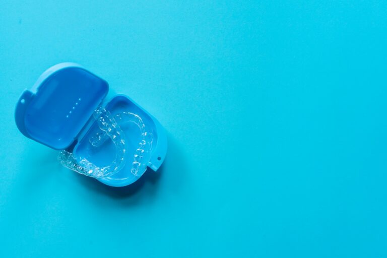 invisalign clear aligners in a blue case against a blue background.