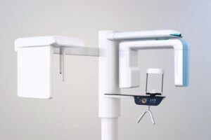 A modern dental X-ray machine with a sleek design, used for taking panoramic images of a patient's mouth and teeth. The machine is positioned in a dental office, showcasing its advanced technology for comprehensive dental diagnostics.